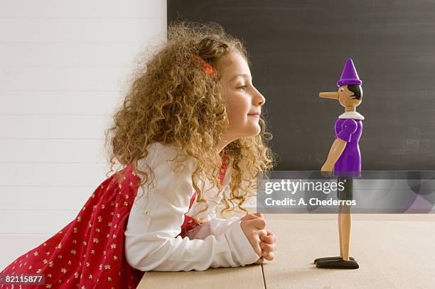 side profile of a girl playing with a toy - pinocchio - fotografias e filmes do acervo