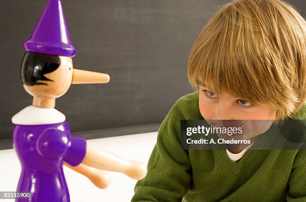 close-up of a boy looking at a toy - pinocchio - fotografias e filmes do acervo