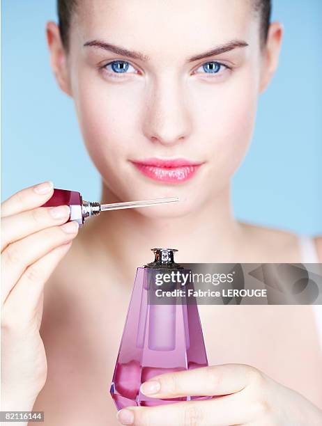 young woman smelling perfume - perfume stockfoto's en -beelden