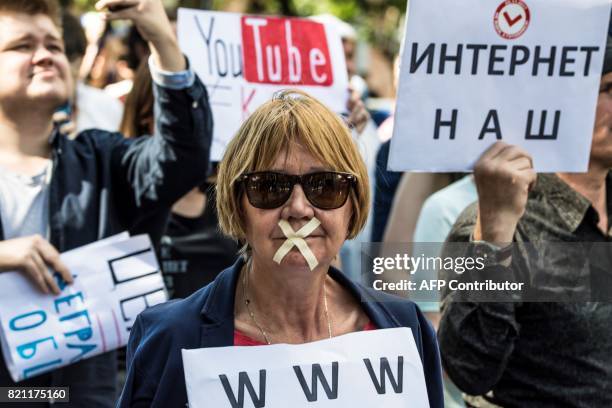 Protester with tape covering her mouth takes part in the March for Free Internet in central Moscow on July 23, 2017. / AFP PHOTO / Mladen ANTONOV