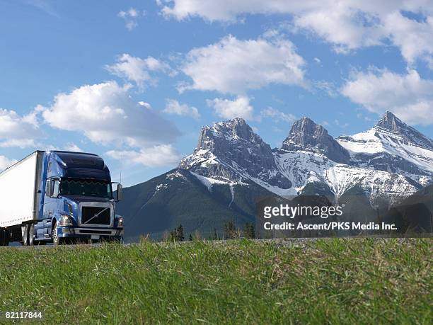 truck on trans-canada highway (#1) passing below three sisters mountain - autostrada transcanadese foto e immagini stock