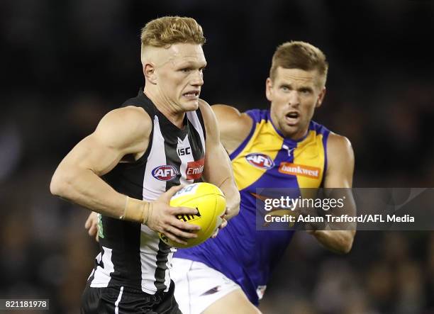 Adam Treloar of the Magpies in action ahead of Mark LeCras of the Eagles during the 2017 AFL round 18 match between the Collingwood Magpies and the...