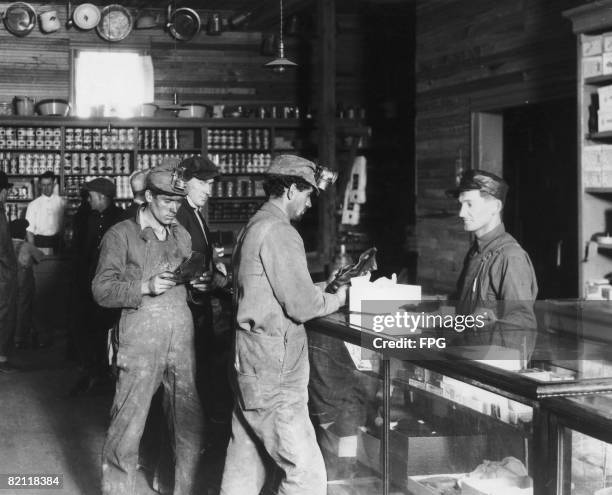 Miners buy shoes at a company store, circa 1925.