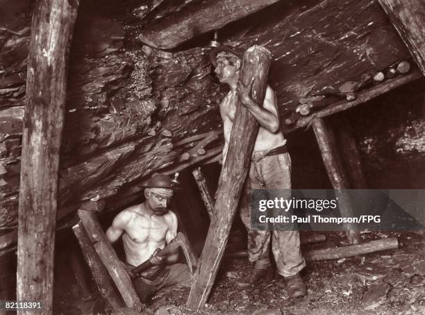 Miners place pit props in position in an Italian coal mine, circa 1900.