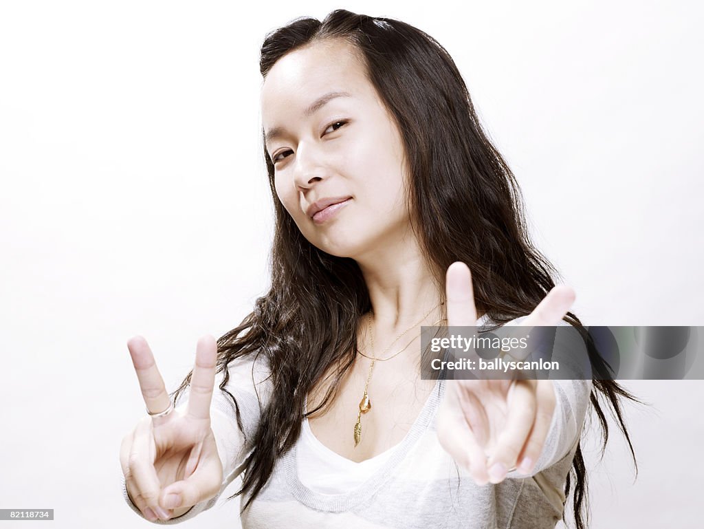 Young asian woman making peace sign with hands