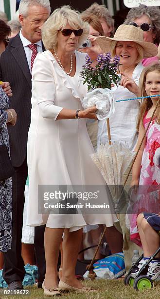 Camilla, Duchess of Cornwall receives flowers from a child during a visit to Sandringham Flower show on July 30, 2008 in Sandringham, England.