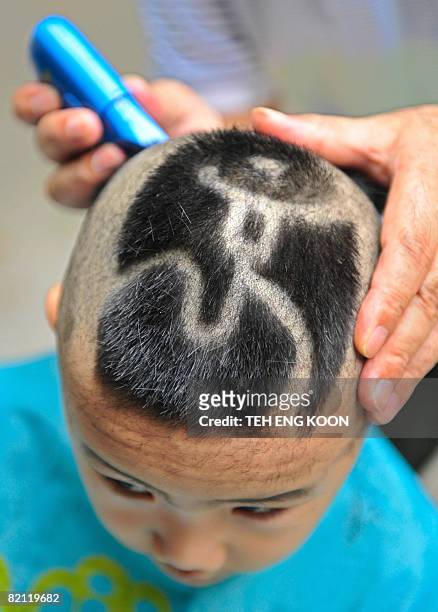 A young Chinese boy has hair cut with Beijing Olympic Games emblem... News  Photo - Getty Images