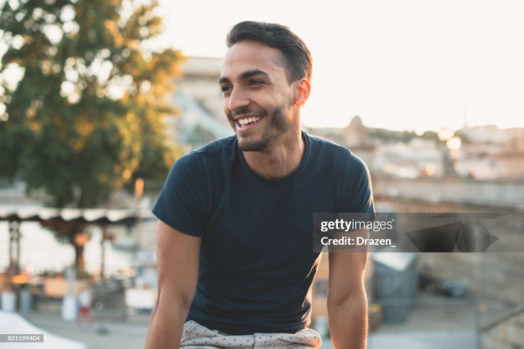 Cheerful Latin man traveling around Europe