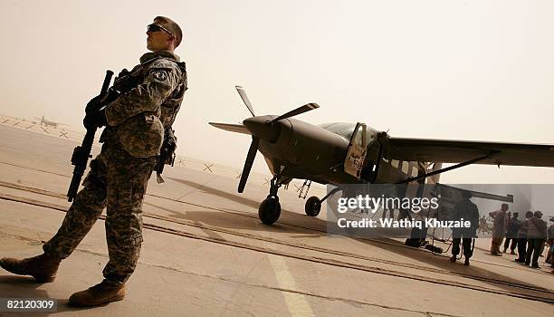 Solider stands guard near the Iraqi air force Caravan Intelligence, Surveillance and Reconnaissance aircraft on July 30, 2008 at the New Al Muthana...
