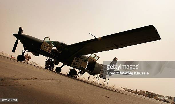 Iraqi air force members and their U.S trainers are seen near the Iraqi air force Caravan Intelligence, Surveillance and Reconnaissance aircraft on...