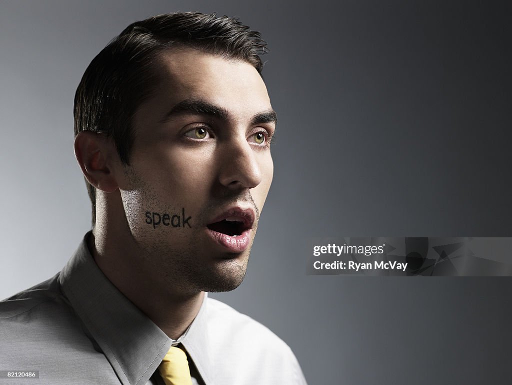 Man with "speak" written on face