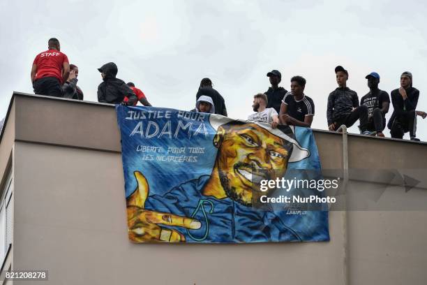 People raise their fists as they take part in a march in memory of Adama Traore, who died during his arrest by the police in July 2016, on July 22,...