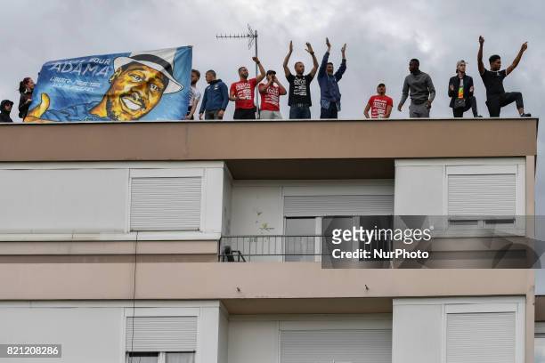 People raise their fists as they take part in a march in memory of Adama Traore, who died during his arrest by the police in July 2016, on July 22,...