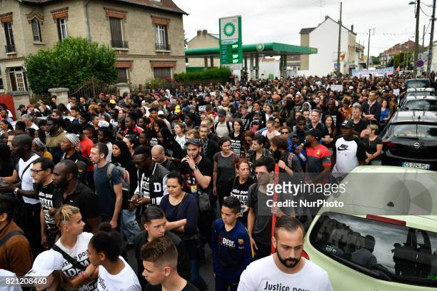 People raise their fists as they take part in a march in memory of Adama Traore, who died during his arrest by the police in July 2016, on July 22,...