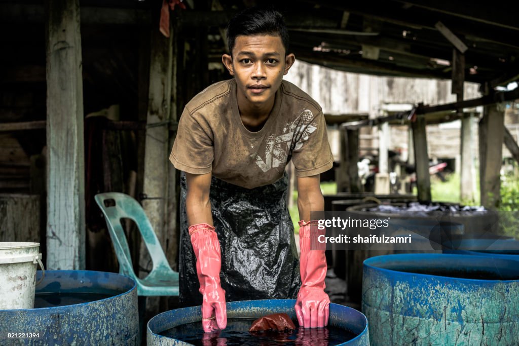 Unidentified man wash a Batik after colouring process