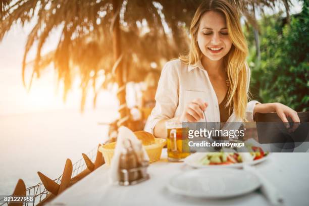 giovane turista bellissimo che mangia cibo mediterraneo nel ristorante greco - pranzo foto e immagini stock