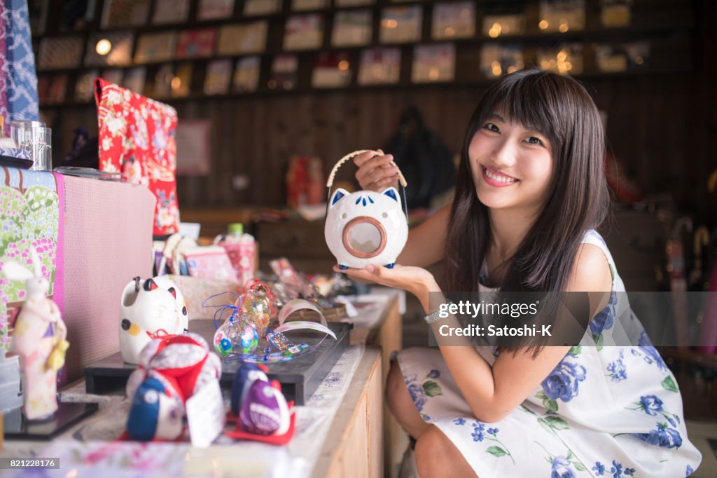 Jonge vrouw met varken vorm aardewerk in traditionele Japanse winkel