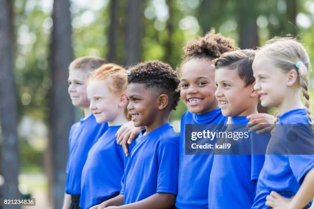 niños multiétnicos en el entrenamiento de fútbol - campamento de verano fotografías e imágenes de stock