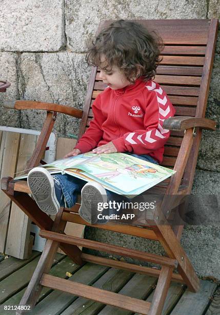 Two year old child looks through a gender-neutral children's book on July 29, 2008 in St-Etienne, France. Two new publishing houses for children's...
