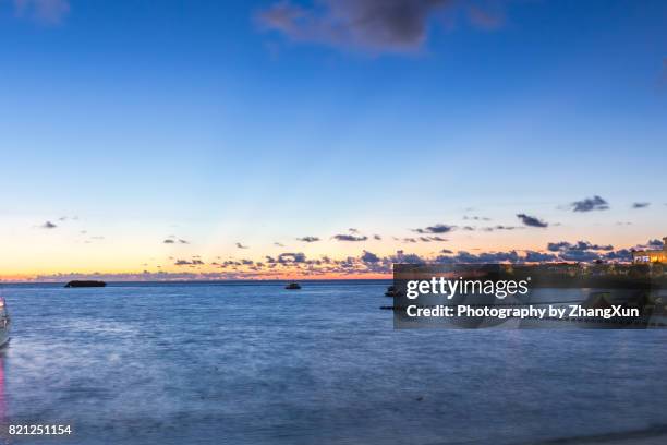 okinawa sunset skyline at manza beach with the background of  sea and sky, naha, okinawa, japan. - okinawa blue sky beach landscape stockfoto's en -beelden