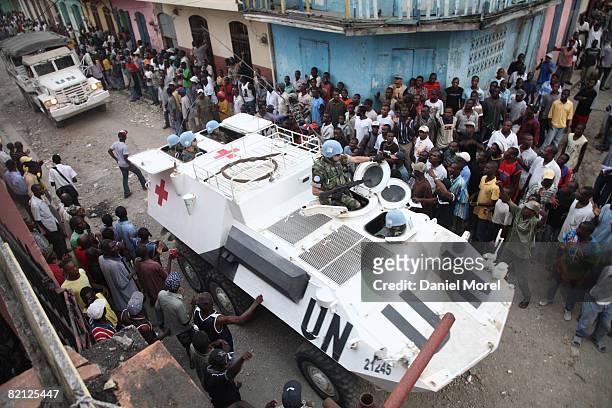 Peacekeepers arrive amongst protesters outside a government building that was seized by former soldiers of the Armed Forces of Haiti July 29, 2008 in...