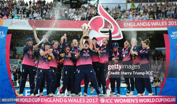 Heather Knight of England lifts the World Cup trophy as the rest of the side celebrate during the ICC Women's World Cup 2017 Final between England...