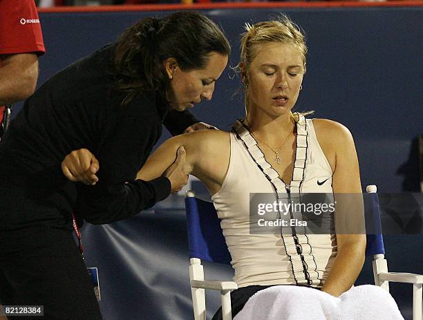 Maria Sharapova of Russia has her shoulder worked on in the second set against Marta Domachowska of Poland during Day 3 of Rogers Cup Tennis on July...
