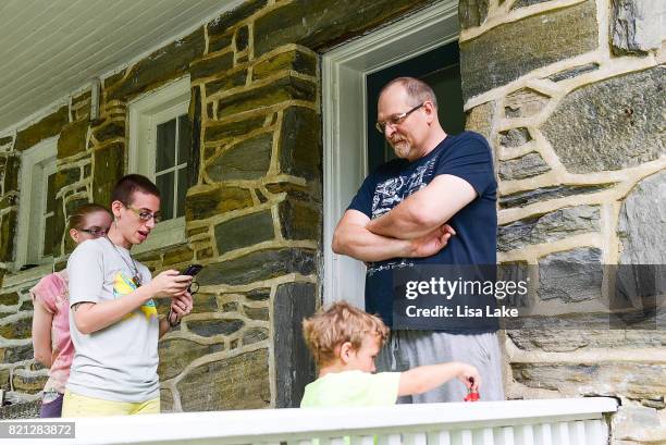 MoveOn.org members talk with neighbor during the Neighborhood Listening Project Healthcare Door Knocking Canvass Event on July 23, 2017 in Ardmore,...