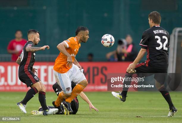 Houston Dynamo midfielder Alex between D.C. United midfielder Luciano Acosta and defender Bobby Boswell during a MLS match between DC United and the...