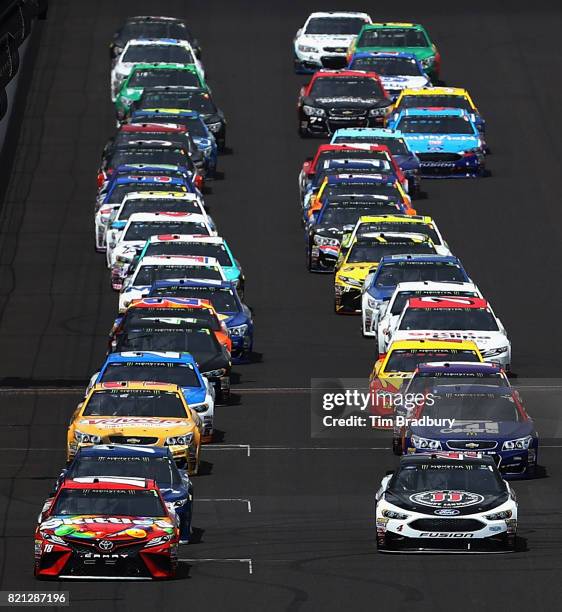 Kyle Busch, driver of the Skittles Toyota, leads the field past the green flag to start the Monster Energy NASCAR Cup Series Brickyard 400 at...