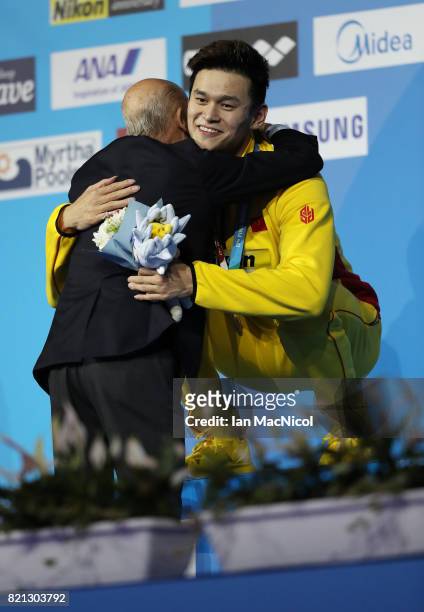 Sun Yang of China hugs Julio Maglione the president of FINA, after receiving his gold medal for winning the Men's 400m Freestyle during day ten of...