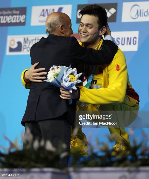 Sun Yang of China hugs Julio Maglione the president of FINA, after receiving his gold medal for winning the Men's 400m Freestyle during day ten of...