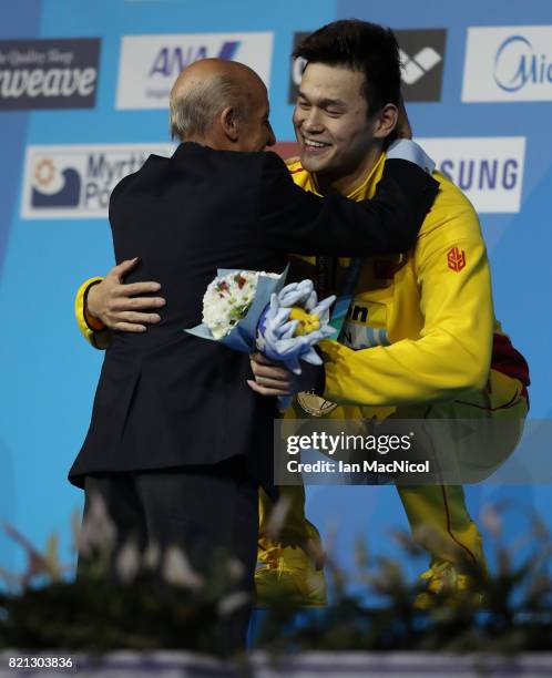 Sun Yang of China hugs Julio Maglione the president of FINA, after receiving his gold medal for winning the Men's 400m Freestyle during day ten of...