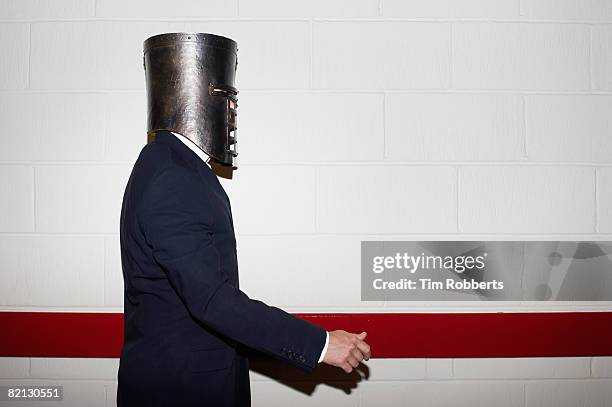 businessman wearing helmet and walking - knight helmet profile stock pictures, royalty-free photos & images