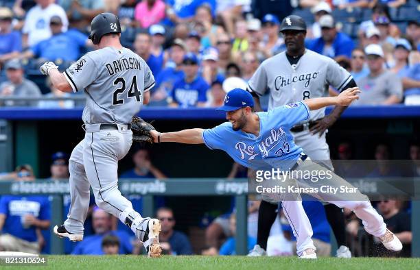 Kansas City Royals first baseman Eric Hosmer reaches back to tag out Chicago White Sox's Matt Davidson on a wide throw from shortstop Alcides Escobar...