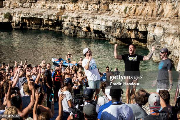 In this handout image provided by Red Bull, Alessandro De Rose of Italy celebrates his win on the podium alongside David Colturi and Andy Jones of...