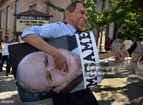 Cody Oliphant, wearing a George W. Bush mask and playing air guitar on a Republican presidential candidate Senator John McCain poster, demonstrates...