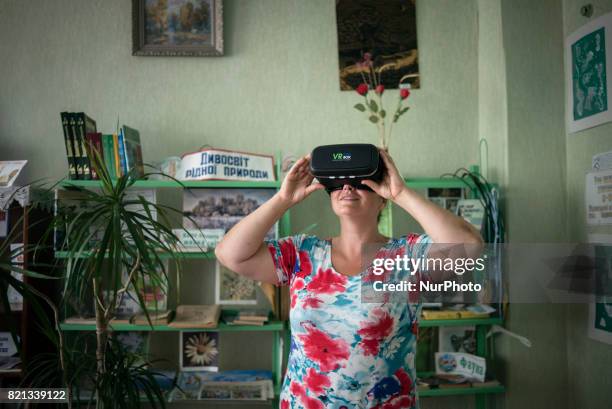 Yana Synytsia wears virtual reality glasses in a village club in Kryva Luka in Donetsk region, ATO zone, Ukraine on July 24, 2017. Yana is a refugee...
