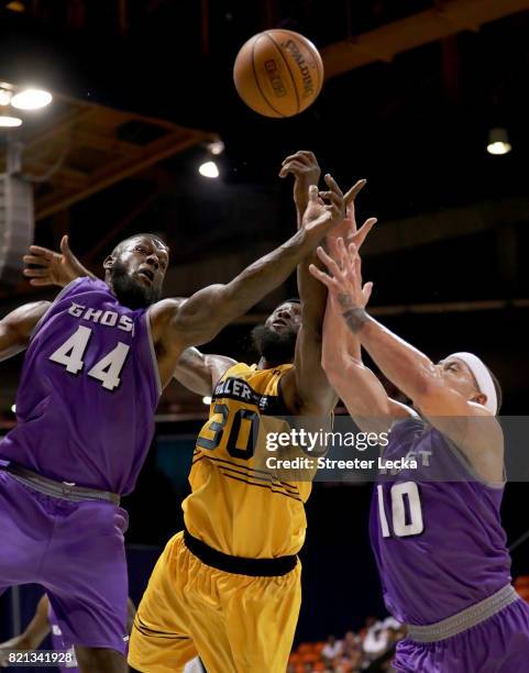 Ivan Johnson and Mike Bibby of the Ghost Ballers battle for a loose ball against Reggie Evans of the Killer 3s during week five of the BIG3 three on...