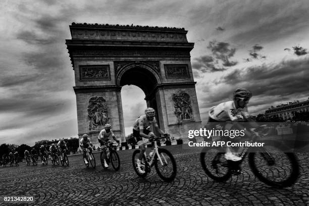 Great Britain's Christopher Froome , wearing the overall leader's yellow jersey, rides past the Arc de Triomphe during the 103 km twenty-first and...