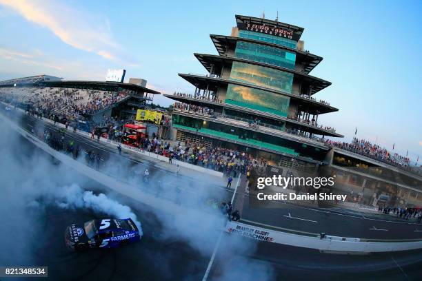 Kasey Kahne, driver of the Farmers Insurance Chevrolet, celebrates with a burnout after winning the Monster Energy NASCAR Cup Series Brickyard 400 at...