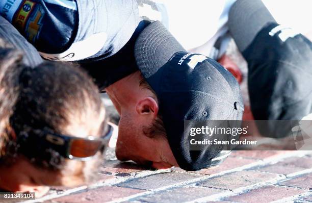 Kasey Kahne, driver of the Farmers Insurance Chevrolet, kisses the yard of bricks with his crew after winning the Monster Energy NASCAR Cup Series...