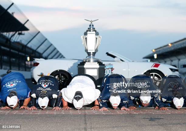 Kasey Kahne, driver of the Farmers Insurance Chevrolet, kisses the yard of bricks with his crew after winning the Monster Energy NASCAR Cup Series...