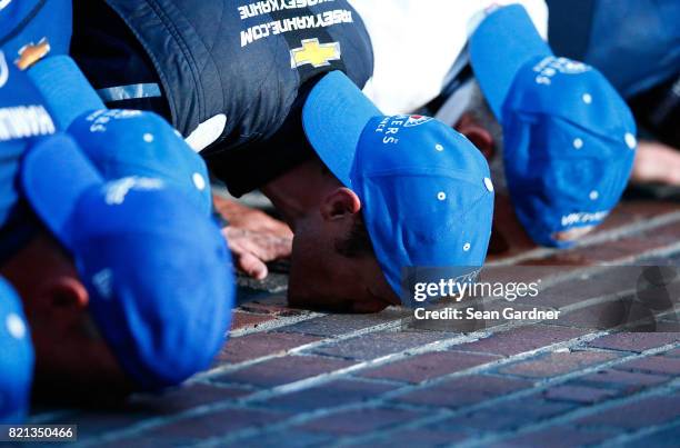 Kasey Kahne, driver of the Farmers Insurance Chevrolet, kisses the yard of bricks with his crew after winning the Monster Energy NASCAR Cup Series...