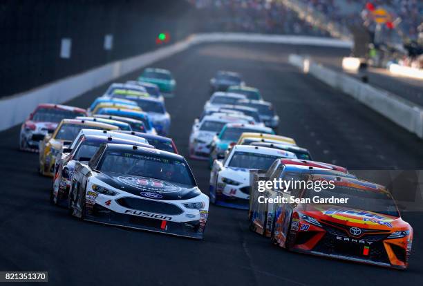 Kevin Harvick, driver of the Jimmy John's Ford, and Matt Kenseth, driver of the Tide Pods Toyota, restart the field during the Monster Energy NASCAR...