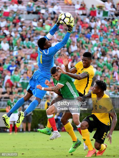 Andre Blake of Jamaica leaps to grab the ball from Orbelin Pineda of Mexico as Damion Lowe and Alvas Powell defend during the first half of the...