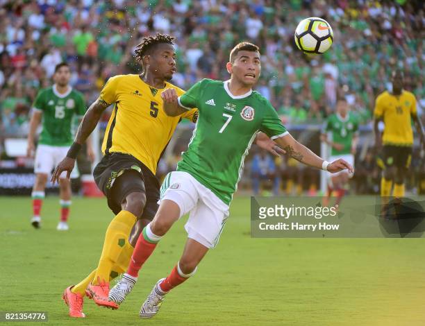 Orbelin Pineda of Mexico attempts to gain control of the ball in front of Alvas Powell of Jamaica during the first half of the CONCACAF 2017...