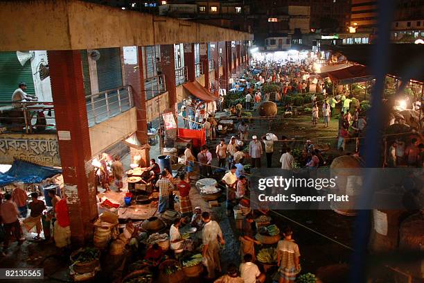 People buy and sell produce at Kawran Bazaar, a sprawling twenty four hour complex of wholesale food markets on July 31, 2008 in Dhaka, Bangladesh....