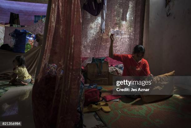 Displaced Marawi resident repairing a pillow inside a makeshift evacuation center on July 23, 2017 in Saguiaran, Lanao del Sur, southern Philippines....