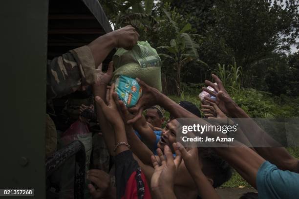 Marawi residents scramble to get food and supplies being handed out by a passing convoy of soldiers on July 21, 2017 in Marawi, southern Philippines....